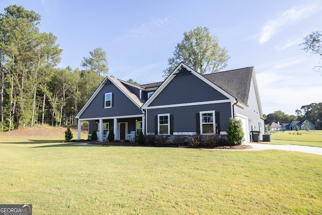 craftsman-style house featuring a garage, cooling unit, covered porch, and a front yard