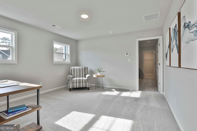 sitting room with plenty of natural light and light carpet