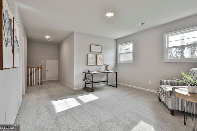 sitting room featuring light colored carpet and a healthy amount of sunlight