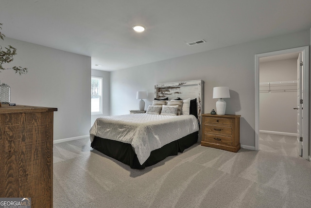 carpeted bedroom with a spacious closet and a closet