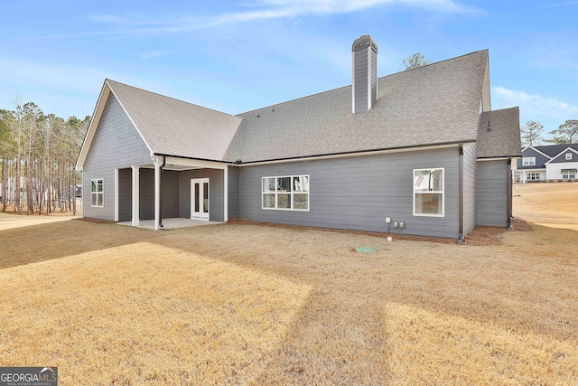 back of house featuring a lawn and a patio