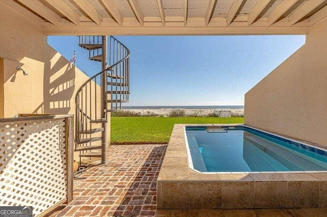 view of swimming pool with a patio area and a water view