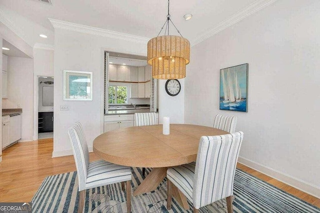 dining area with ornamental molding and light wood-type flooring