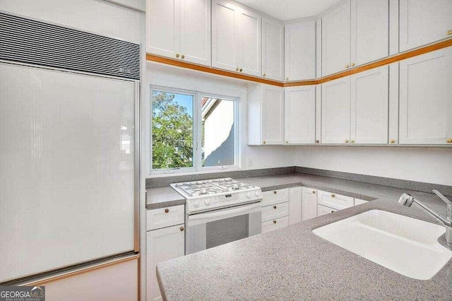 kitchen with white cabinets, sink, paneled built in refrigerator, and white electric range oven