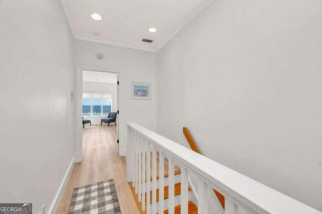 hall featuring crown molding and light hardwood / wood-style flooring