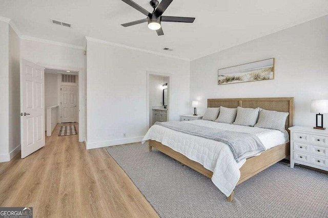 bedroom featuring wood-type flooring, ensuite bath, ceiling fan, and crown molding