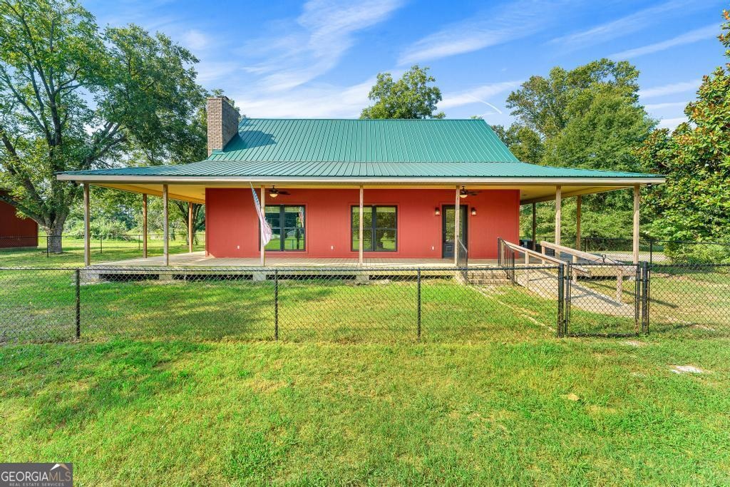 back of property featuring a porch and a yard