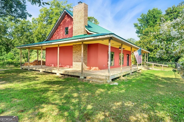 view of side of home with a lawn and ceiling fan