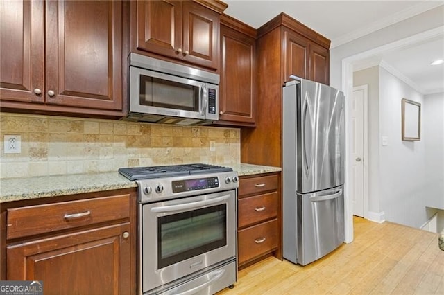 kitchen featuring appliances with stainless steel finishes, light hardwood / wood-style floors, light stone counters, and crown molding