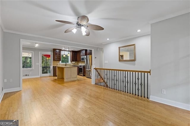 unfurnished living room with light hardwood / wood-style floors, ceiling fan, crown molding, and sink