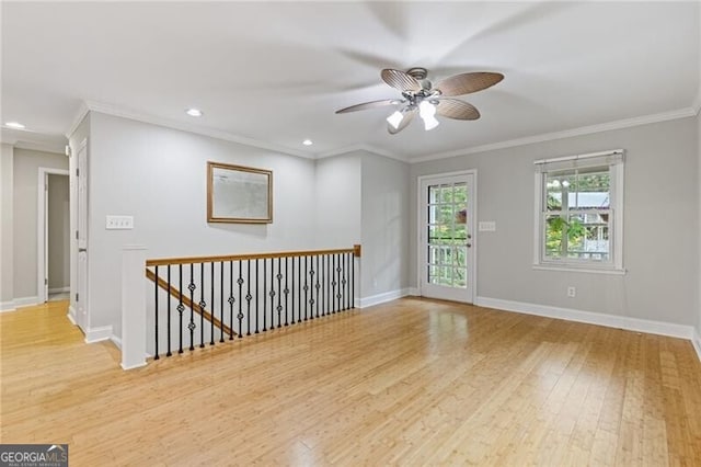 empty room featuring ceiling fan, light hardwood / wood-style floors, and crown molding