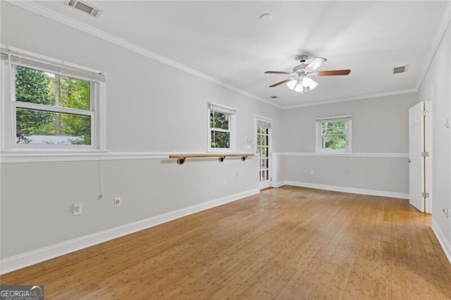 empty room with plenty of natural light, ceiling fan, crown molding, and light hardwood / wood-style flooring