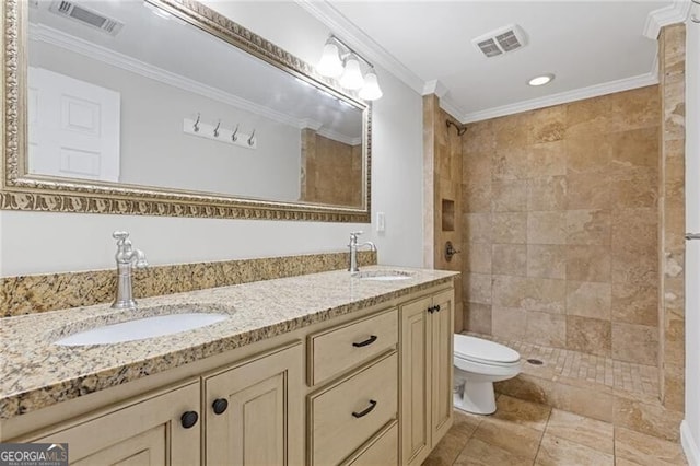 bathroom featuring a tile shower, vanity, toilet, and crown molding