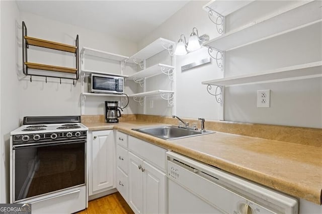 kitchen featuring sink, stove, white dishwasher, light hardwood / wood-style floors, and white cabinets