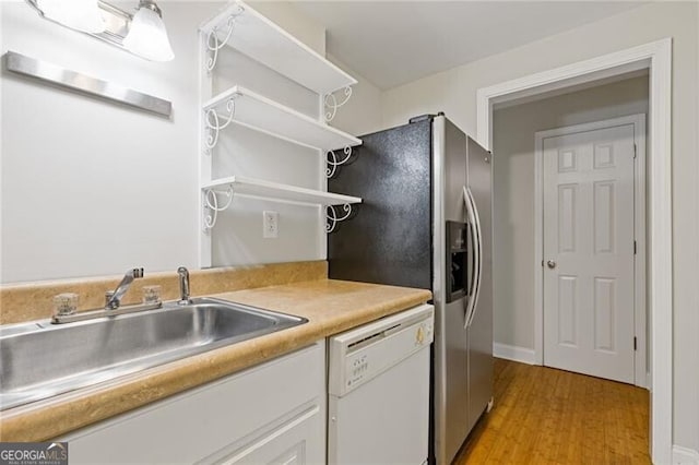 kitchen with white dishwasher, white cabinets, sink, stainless steel refrigerator with ice dispenser, and light hardwood / wood-style floors