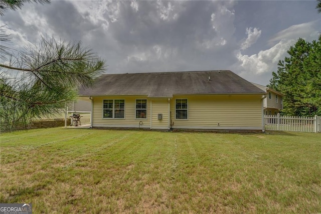 rear view of house featuring a lawn