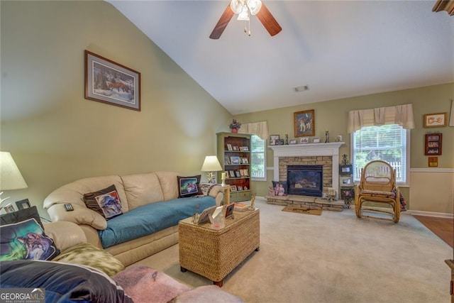 carpeted living room featuring a stone fireplace, ceiling fan, and lofted ceiling