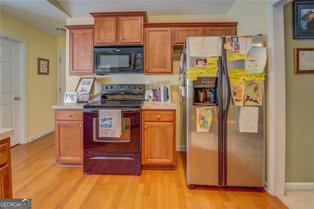 kitchen featuring black appliances and light hardwood / wood-style flooring