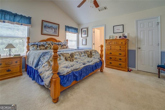 bedroom featuring light carpet, vaulted ceiling, multiple windows, and ceiling fan