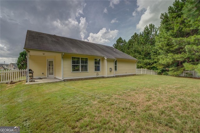 rear view of property with a yard and a patio area