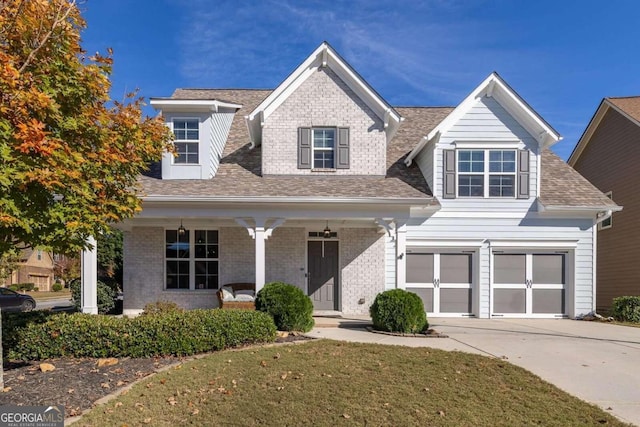 view of front of home with a garage, a front yard, and a porch