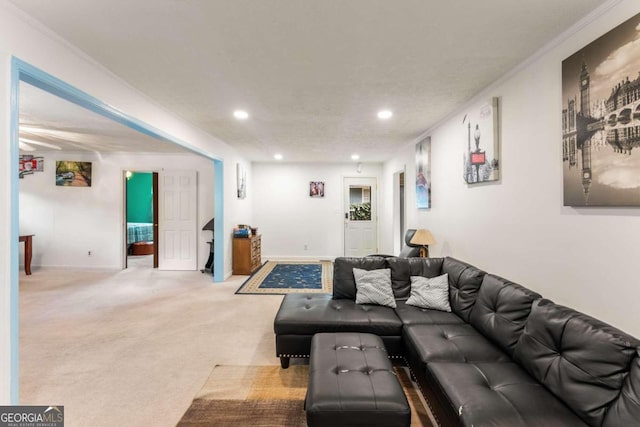 living room featuring a textured ceiling, crown molding, and light carpet