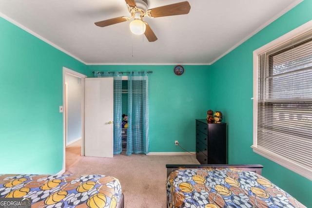 carpeted bedroom featuring ceiling fan and crown molding