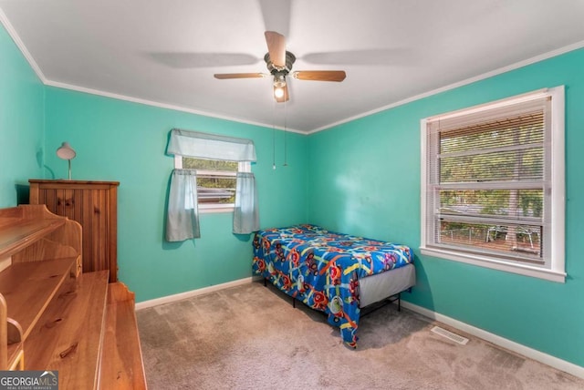 carpeted bedroom featuring ceiling fan and ornamental molding