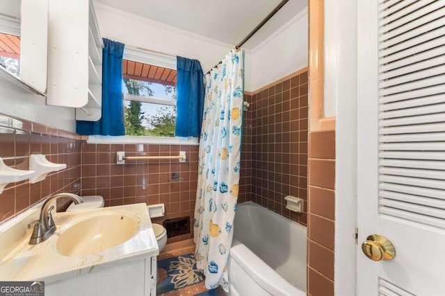 full bathroom with crown molding, toilet, shower / bath combo with shower curtain, vanity, and tile walls