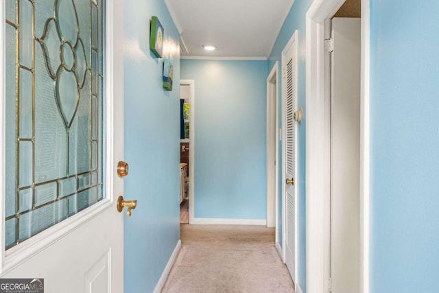 hallway with light carpet and crown molding