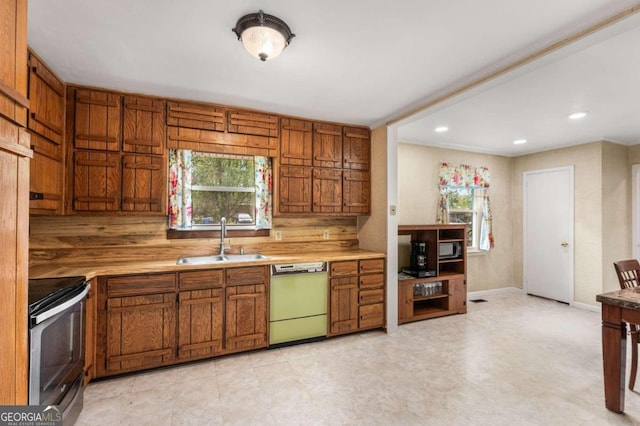 kitchen with decorative backsplash, sink, white dishwasher, and stainless steel range oven