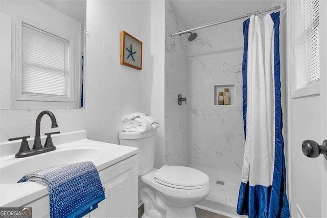 bathroom with walk in shower, vanity, and toilet