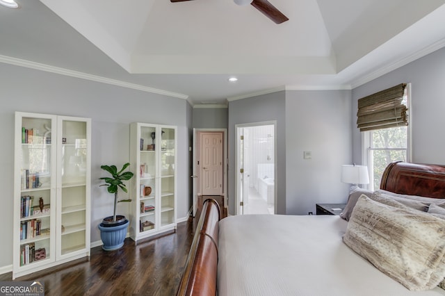 bedroom featuring ornamental molding, ceiling fan, a tray ceiling, connected bathroom, and dark hardwood / wood-style flooring