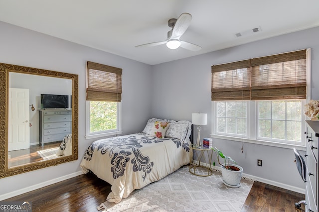 bedroom with multiple windows, hardwood / wood-style flooring, and ceiling fan