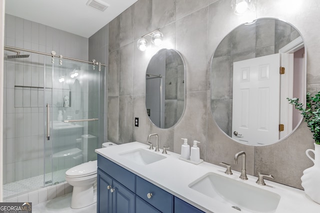 bathroom featuring walk in shower, vanity, tile walls, and toilet