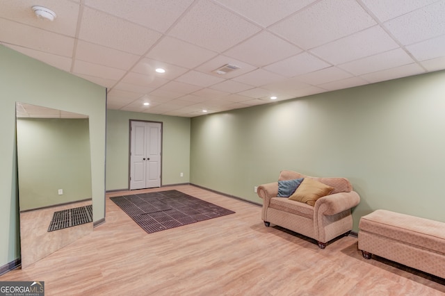 sitting room featuring a drop ceiling and light hardwood / wood-style floors