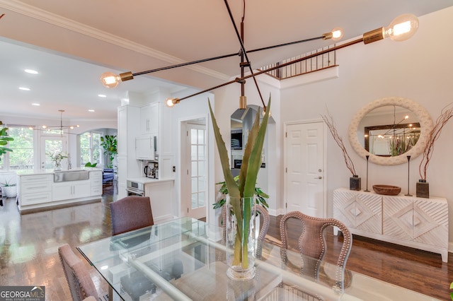 dining area featuring a chandelier, dark hardwood / wood-style floors, crown molding, and sink