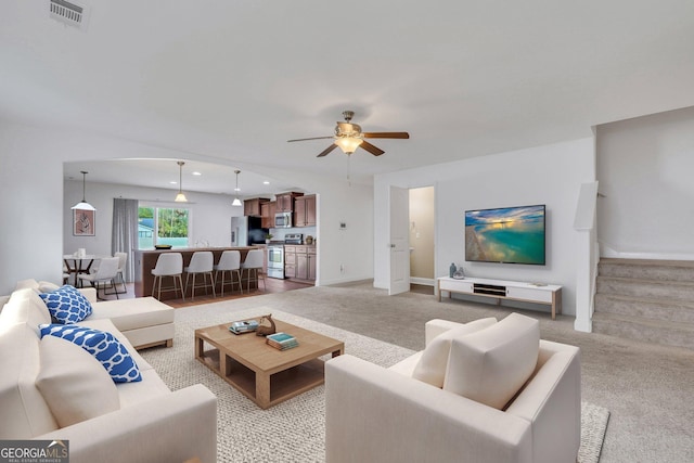 living room with light carpet and ceiling fan