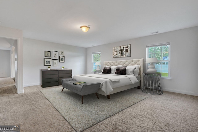 bedroom with carpet floors and multiple windows