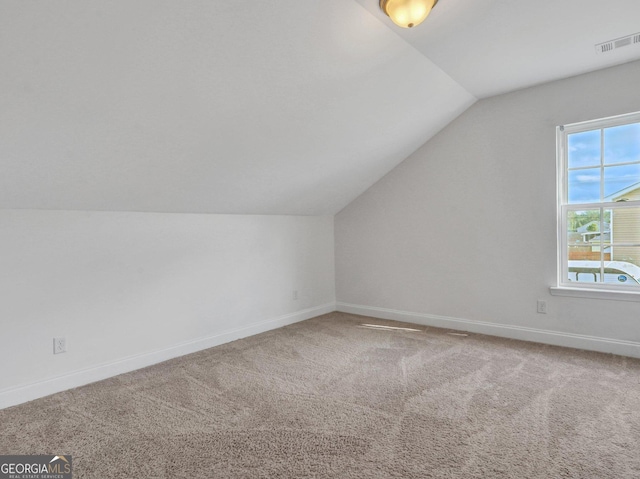 bonus room with vaulted ceiling and carpet floors