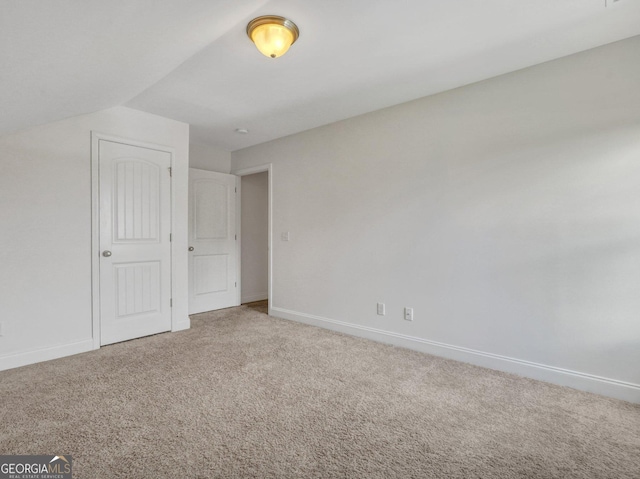 unfurnished bedroom featuring carpet and lofted ceiling