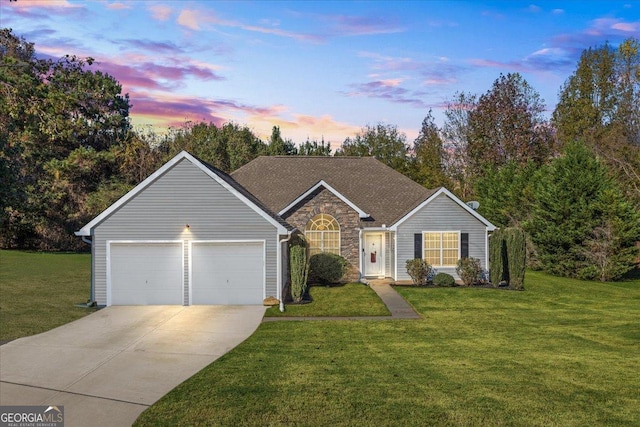 single story home with a garage and a yard