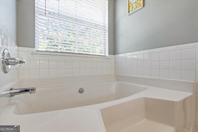 bathroom featuring a wealth of natural light and a bath