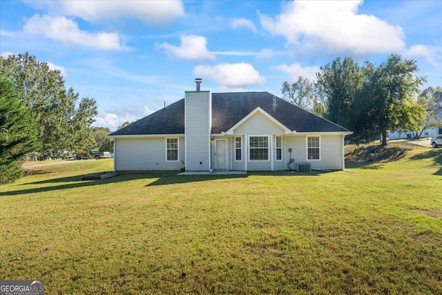 rear view of property featuring a yard and central AC