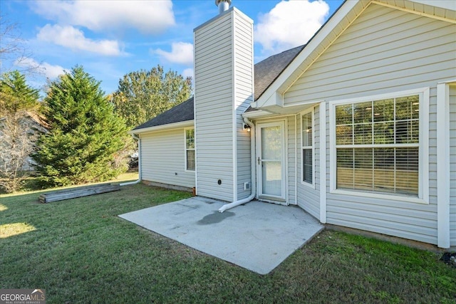 rear view of house with a yard and a patio