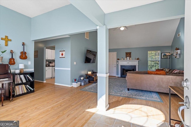 living room with light wood-type flooring and high vaulted ceiling