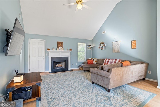 living room featuring ceiling fan, high vaulted ceiling, and hardwood / wood-style flooring