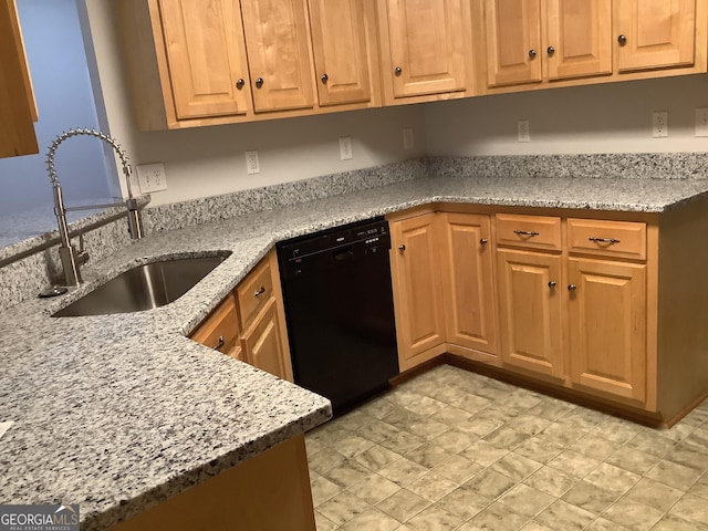 kitchen featuring sink, light stone countertops, and black dishwasher