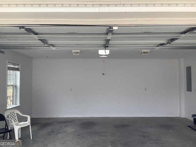 garage with a garage door opener and electric panel