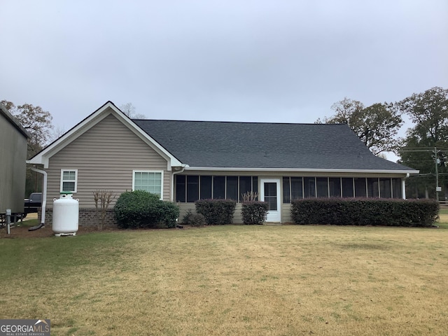 view of front of property with a sunroom and a front yard